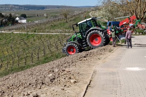 Weinbergsarbeit beim Pflanzen. Im Bild zu sehen Traktor an Hangfläche.