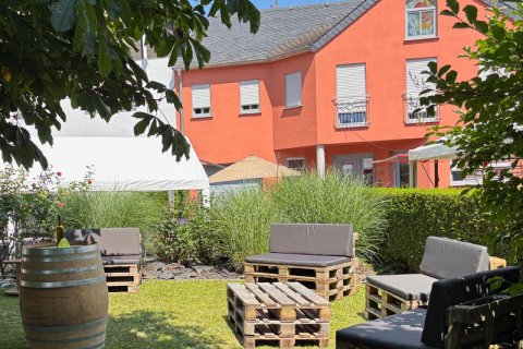 Hoffest Sitzgelegenheit Wiese Sitzgelegenheiten aus Paletten und Weinfass auf Grünfläche. Im Hintergrund Ausschnitt der Fassade vom Weingut Löwen.