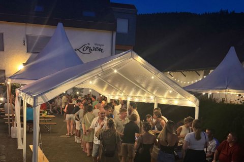 Abendstimmung Hoffest Abendimpression vom Hoffest mit Blick auf die beleuchteten Zelte, unter denen die Gäste sitzend und stehend das Fest genießen. Im Hintergrund ist das Weingut zu sehen.