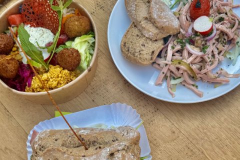 Mehrere Speisen zum Hoffest Drei Speisen mit einer Bowl im linken Bildbereich, einem Teller mit Wurstsalat im rechten Bildbereich. davor belegtes Brötchen.