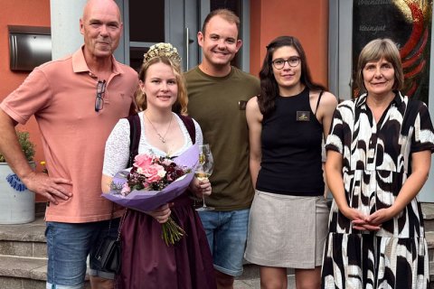 Familie-Gruppenbild mit unserer Weinkönigin Familie-Gruppenbild mit der Mehringer Weinkönigin, die einen Blumenstrauß und ein Weinglas in der Hand hält.